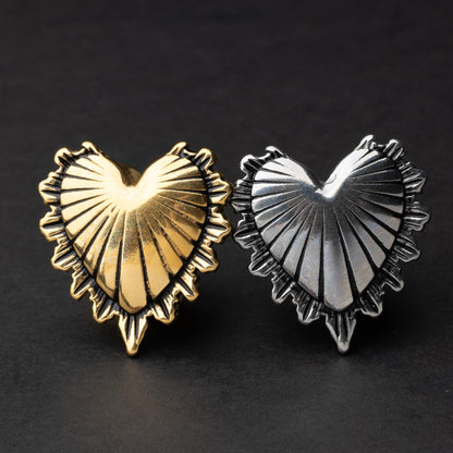 Sacred Heart plugs in gold and silver finishes, showcasing intricate 3D heart designs with a radiant pattern, displayed on a matte dark background.