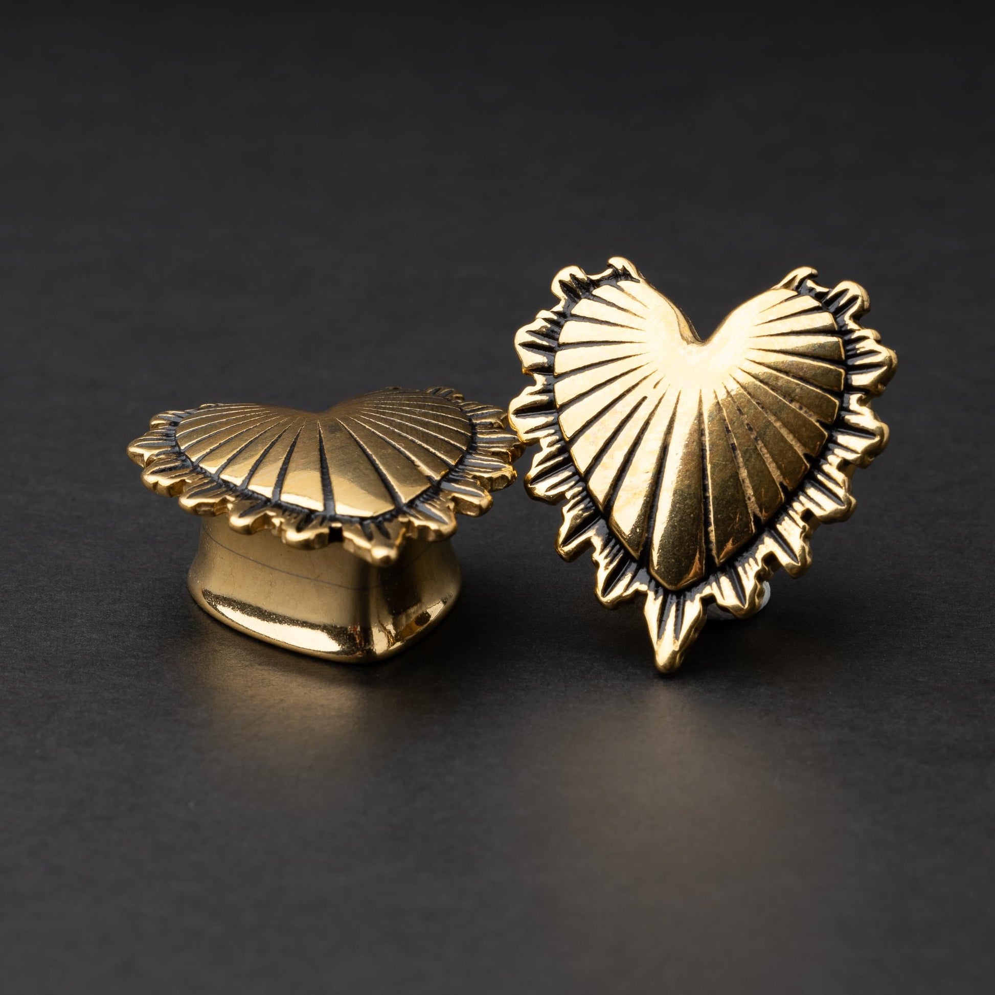 Sacred Heart plugs in gold, showcasing intricate 3D heart designs with a radiant pattern, displayed on a matte dark background.