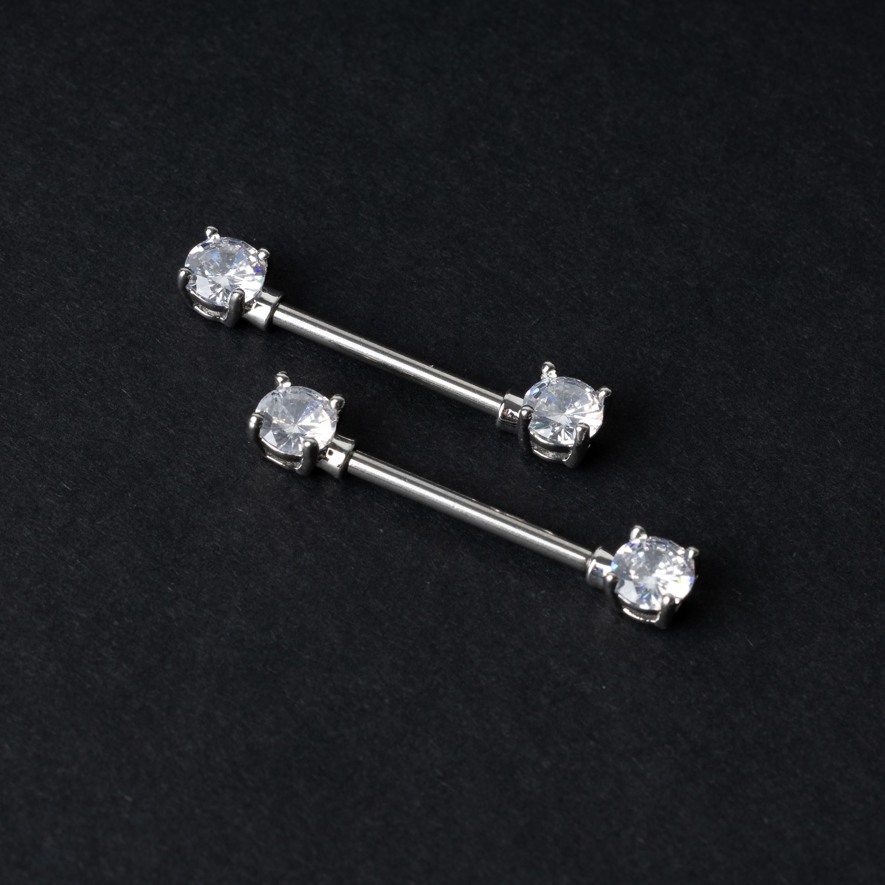 Crystal-studded barbells in silver displayed on a dark background.
