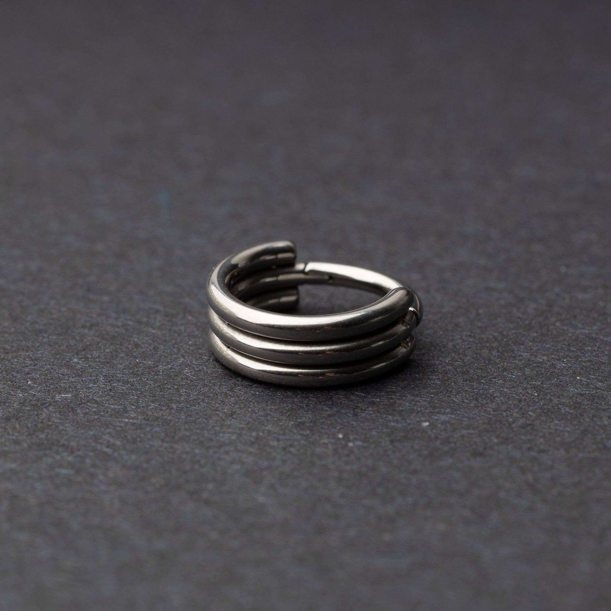 Triple-band seamless hoop rings in a silver finish displayed on a dark background, highlighting their sleek and modern design.