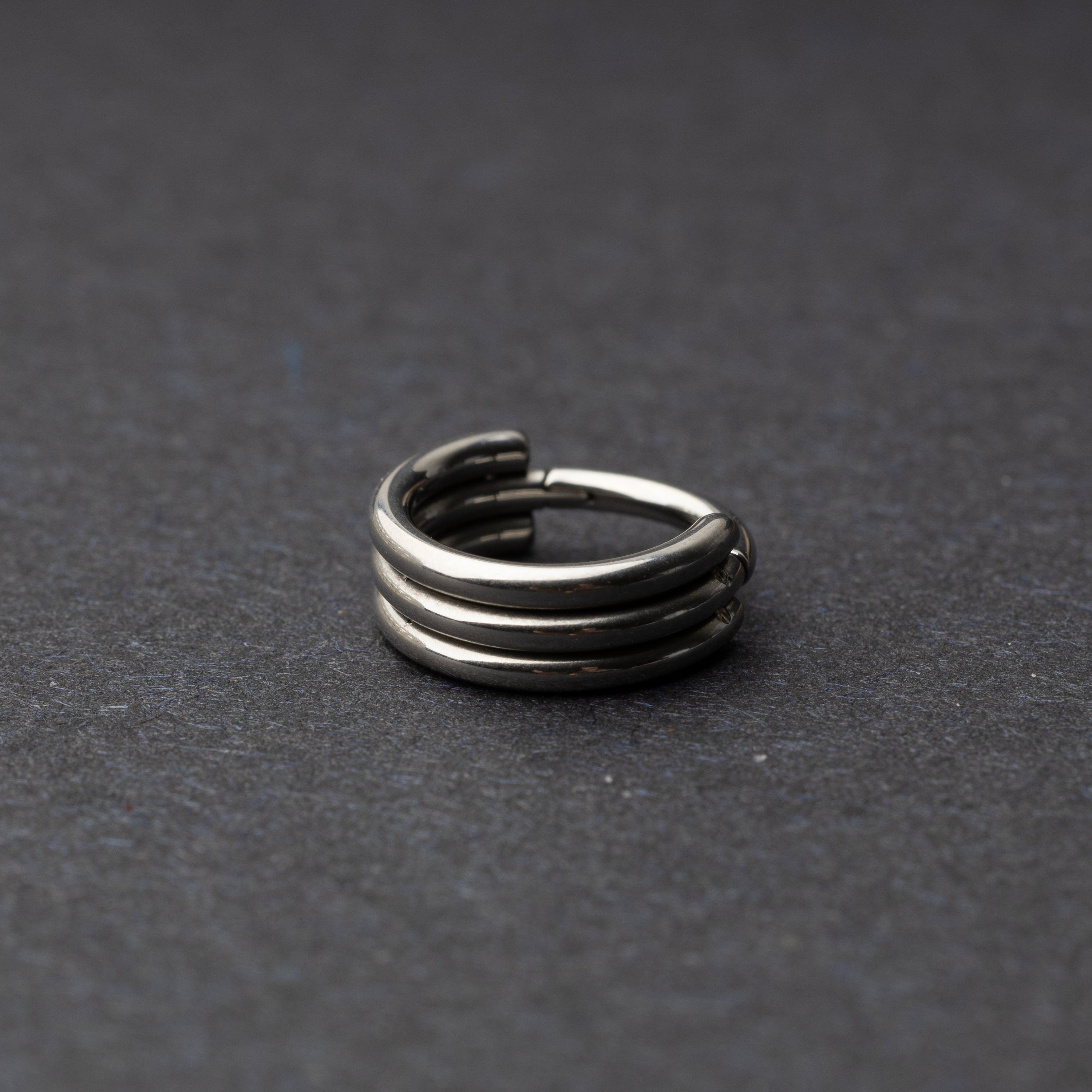 Triple-band seamless hoop rings in a silver finish displayed on a dark background, highlighting their sleek and modern design.