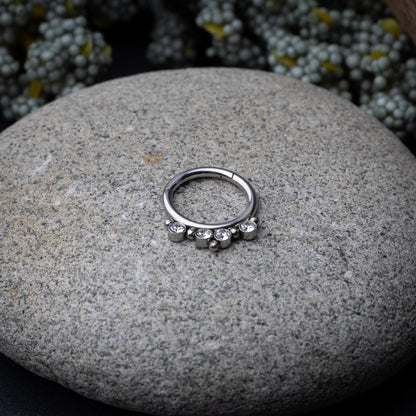 A stainless steel clicker with clear gemstones and bead accents, suitable for septum or daith piercings.