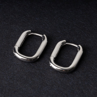 Four rectangular huggie hoop earrings made from 925 sterling silver, two in gold-tone and two in silver-tone, displayed on a dark background.