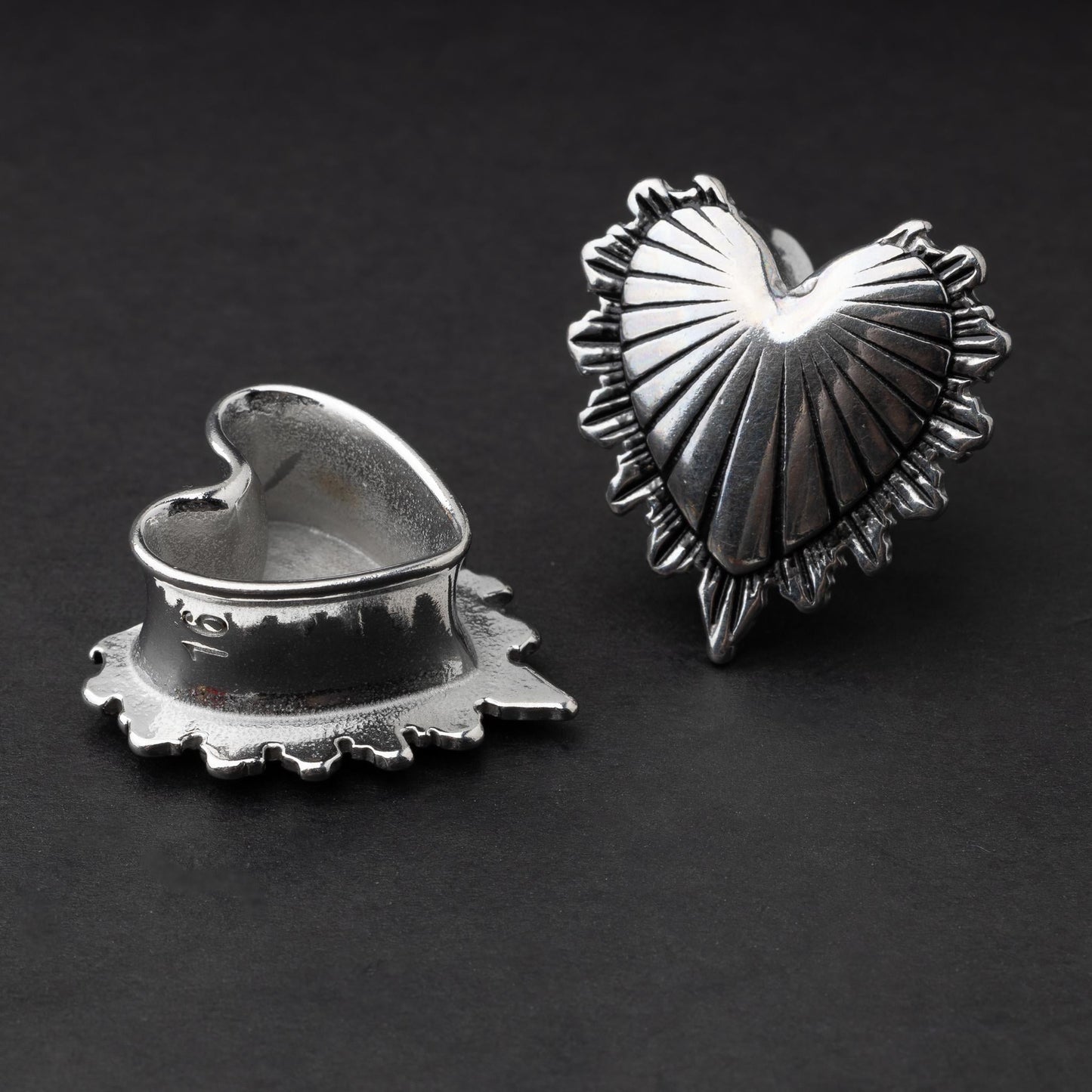 Sacred Heart plugs in gold and silver finishes, showcasing intricate 3D heart designs with a radiant pattern, displayed on a matte dark background.