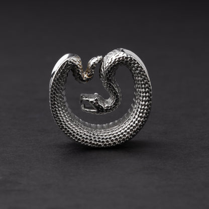 Silver Snake-shaped saddle plugs, displayed on a dark background.