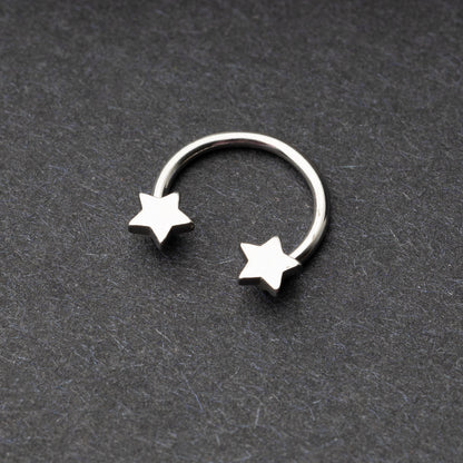 Stainless steel horseshoe hoop with star-shaped ends displayed on a dark background.