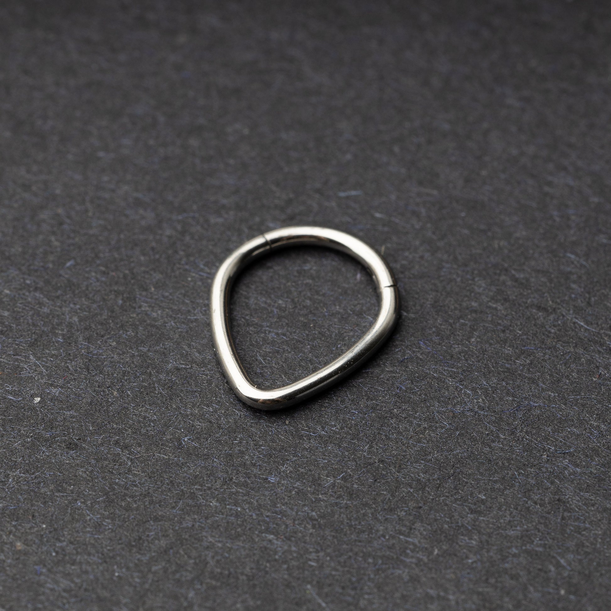 Silver Teardrop Clicker displayed on a dark background