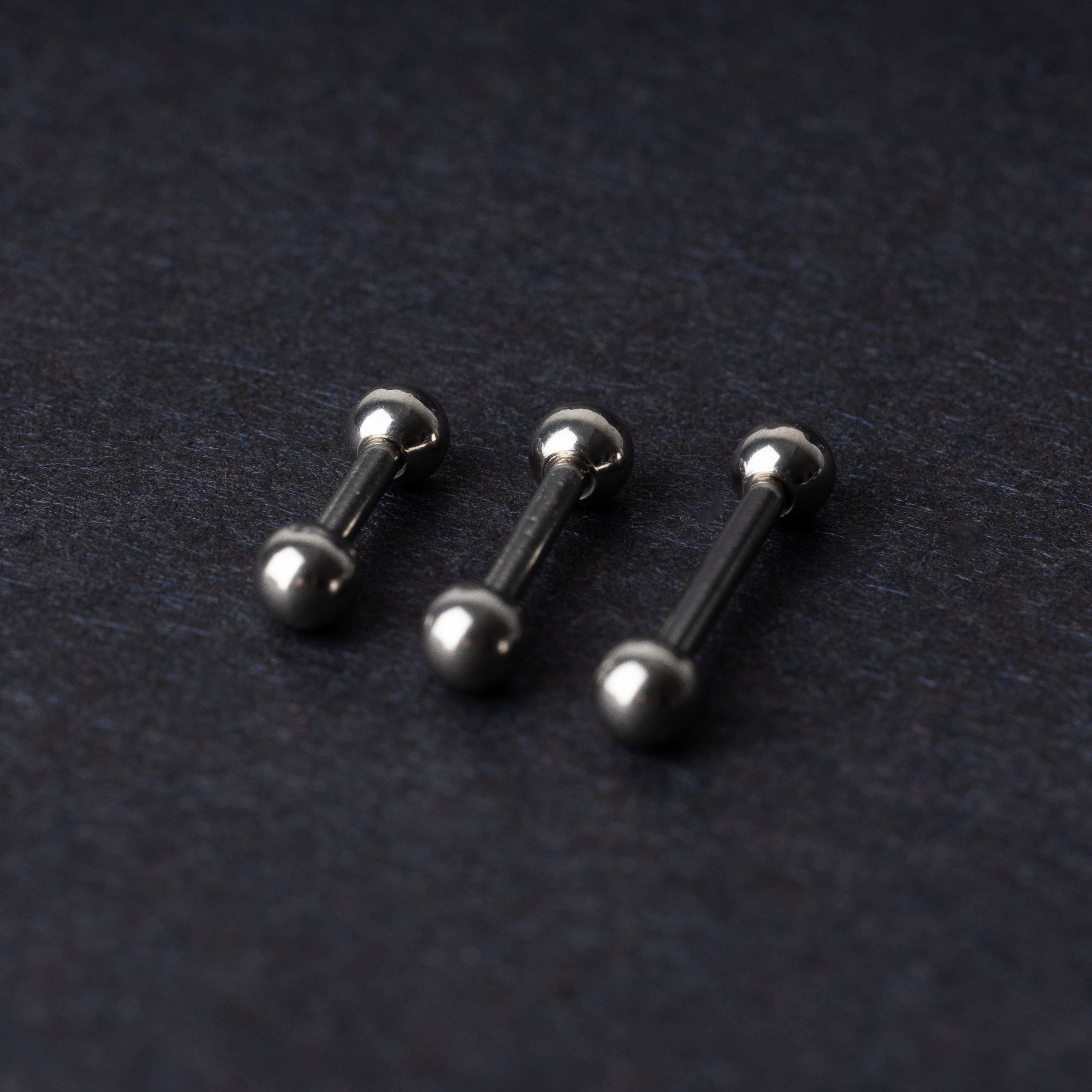 Stainless steel barbells on a dark background.