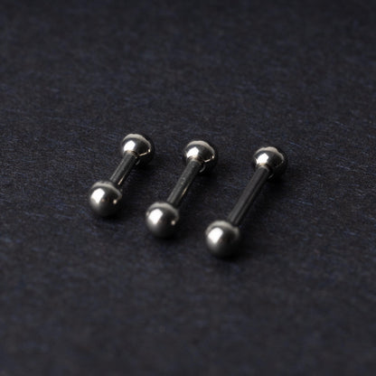 Stainless steel barbells on a dark background.