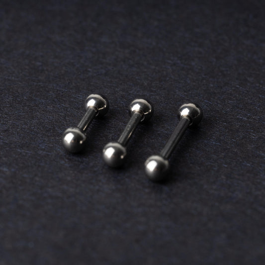 Stainless steel barbells on a dark background.