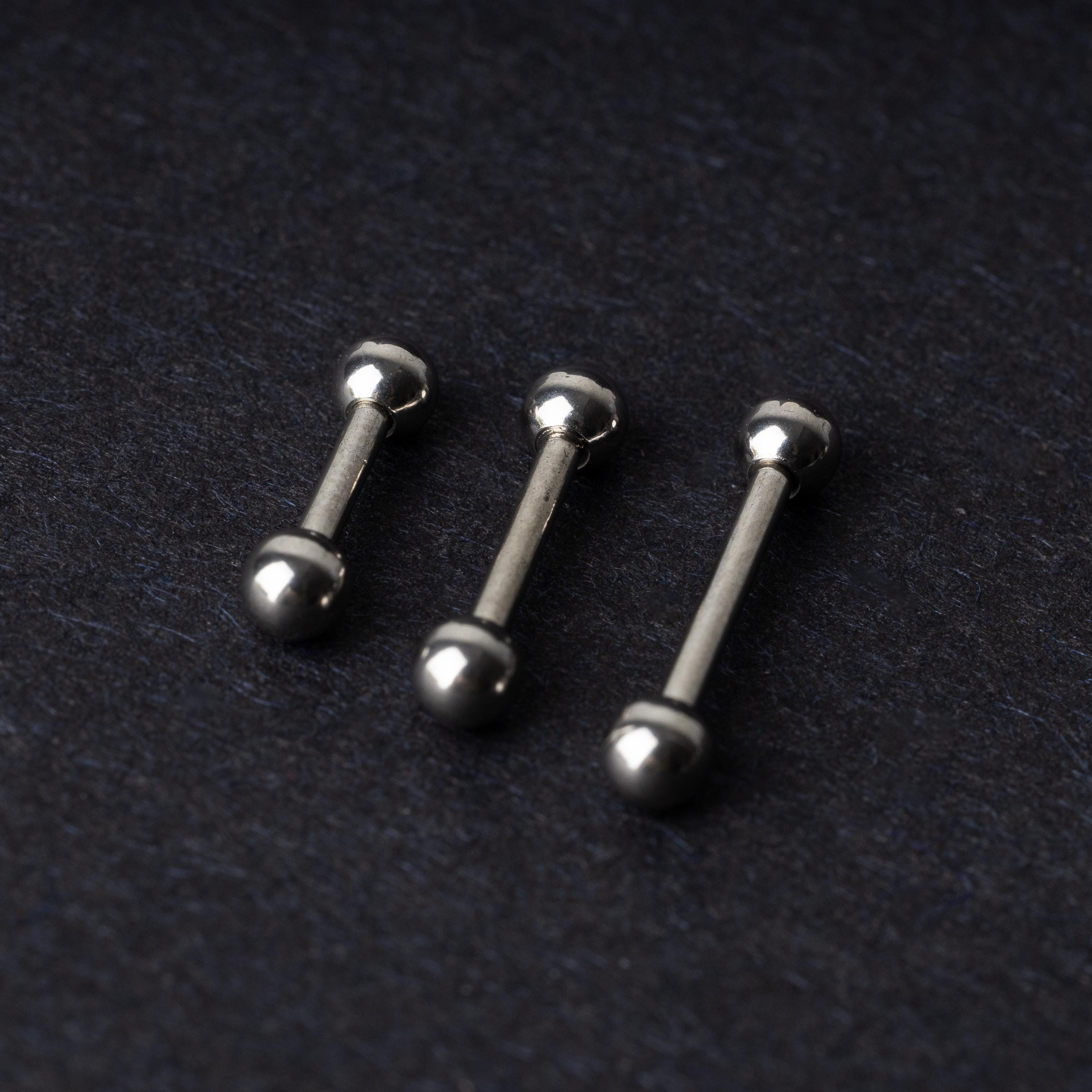 Stainless steel barbells on a dark background.