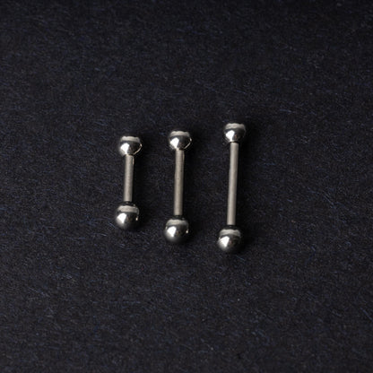 Stainless steel barbells on a dark background.