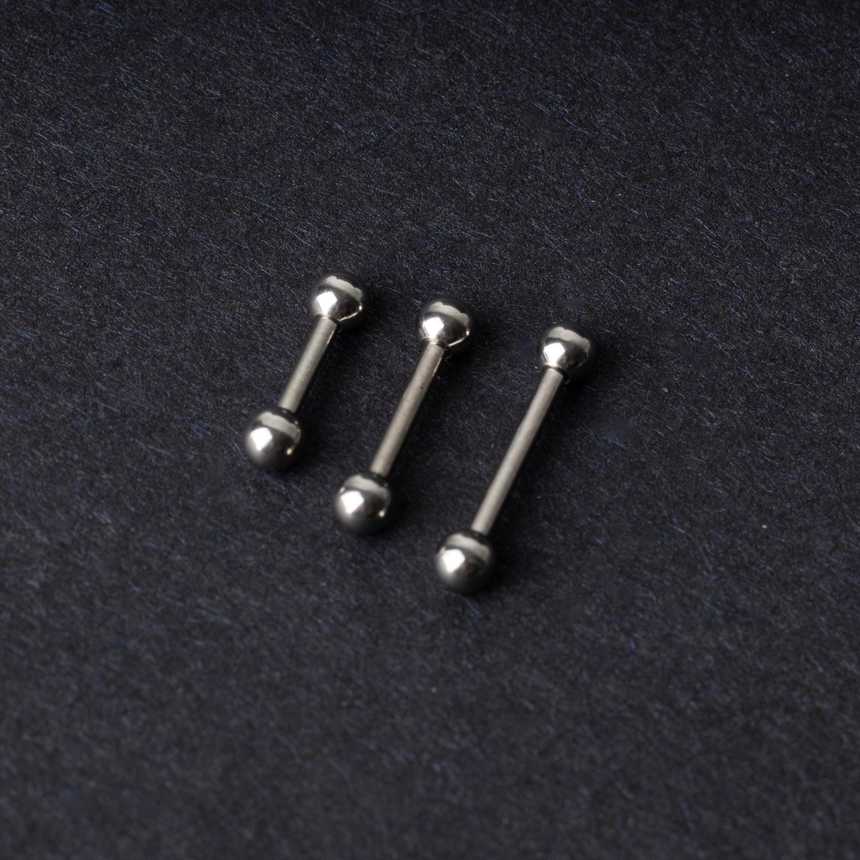 Stainless steel barbells on a dark background.