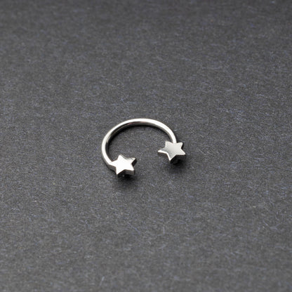 Stainless steel horseshoe hoop with star-shaped ends displayed on a dark background.