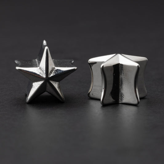 Stainless steel star-shaped plugs for stretched ears, displayed on a dark background.