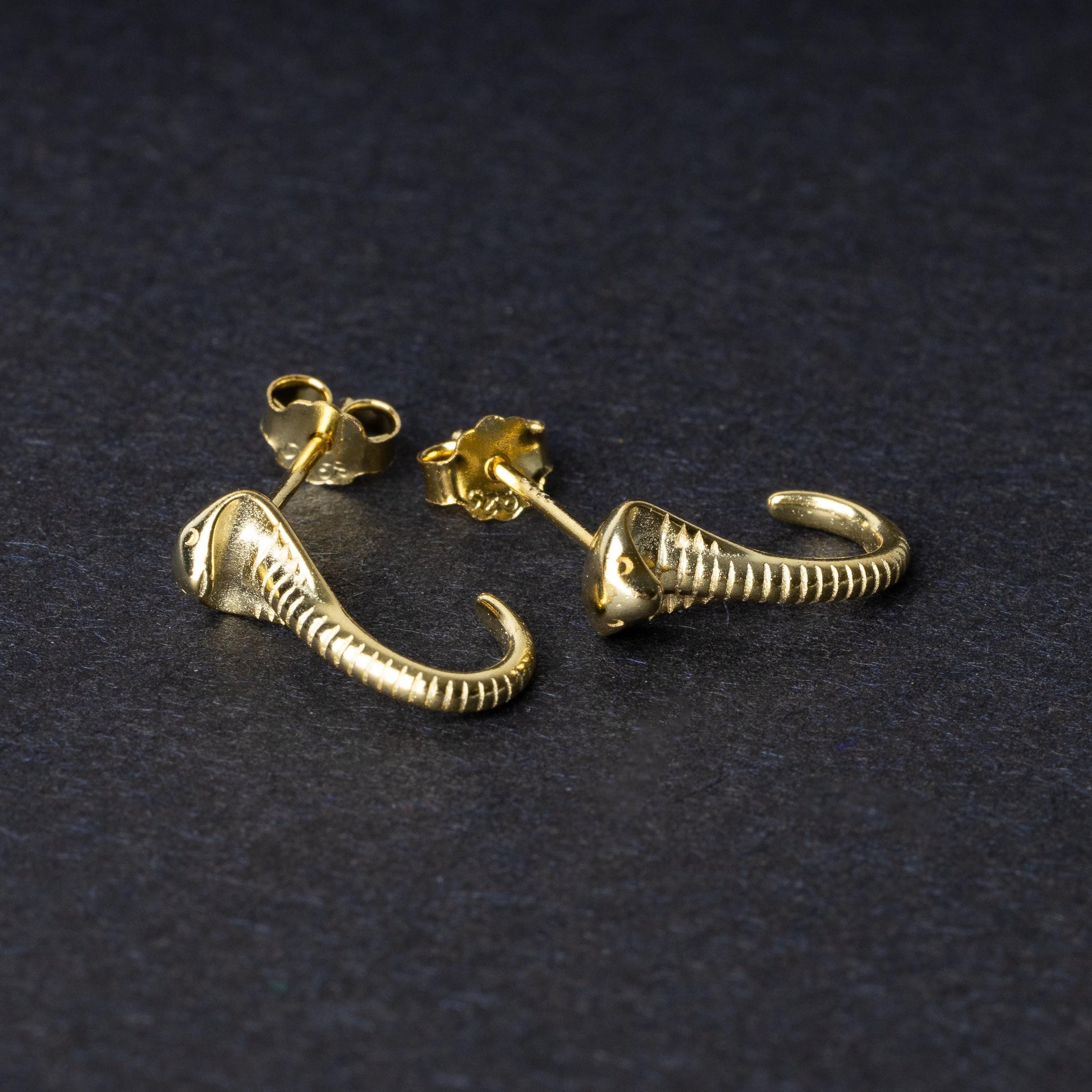 Gold-toned cobra-shaped stud earrings with intricate detailing, crafted from 925 sterling silver, displayed on a black background.