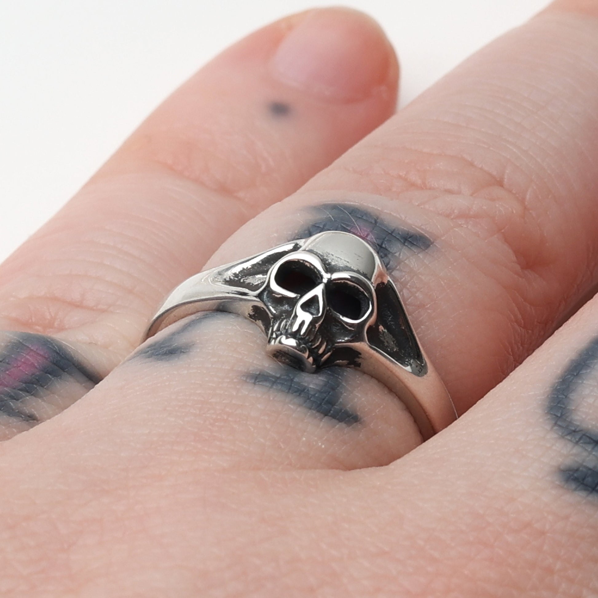Sterling silver ring featuring a detailed skull design, displayed on a Models finger.