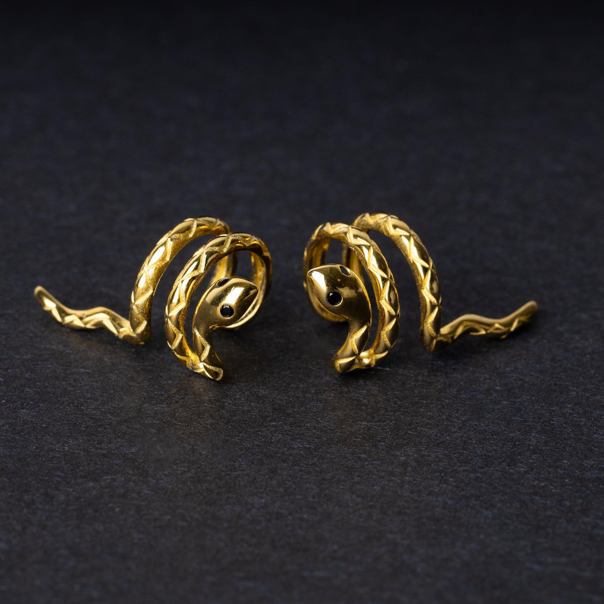 Gold-toned snake-shaped ear cuff made from 925 sterling silver, featuring a coiled design with intricate scales, displayed on a black background.