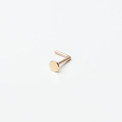 Solid gold nose stud with a flat disc design, displayed on a white background.