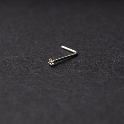 925 sterling silver nose stud with a small crystal accent, displayed on a dark textured background.