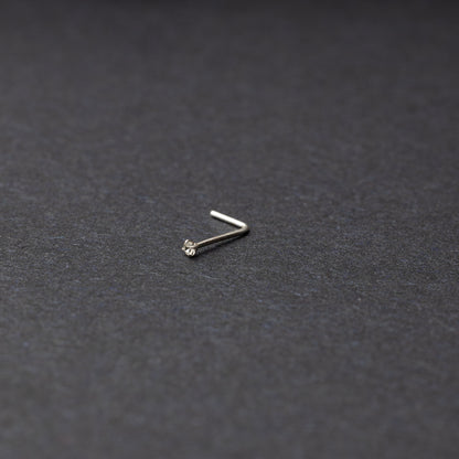 925 sterling silver nose stud with a small crystal accent, displayed on a dark textured background.