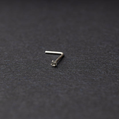 925 sterling silver nose stud with a small crystal accent, displayed on a dark textured background.
