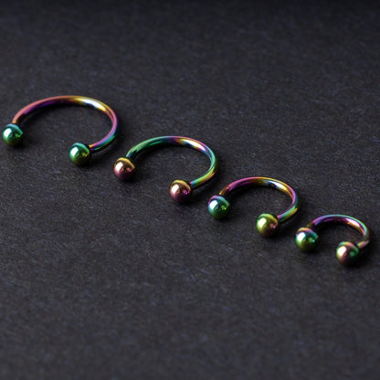 Titanium Rainbow Horseshoe Hoops in Rainbow on a dark background