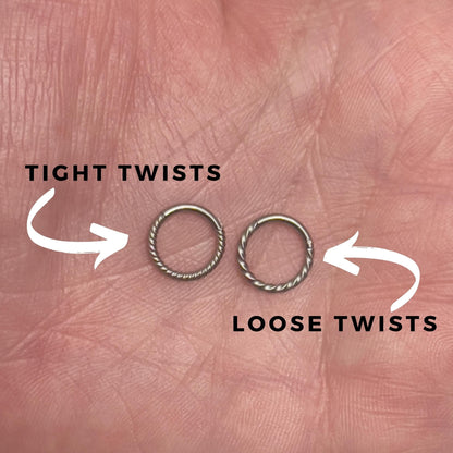 Two twisted clicker rings displayed on a hand with annotations detailing the difference between loose and tight twists. 