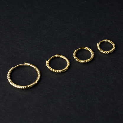 Gold rope-textured clicker rings in four different sizes, displayed on a dark background.