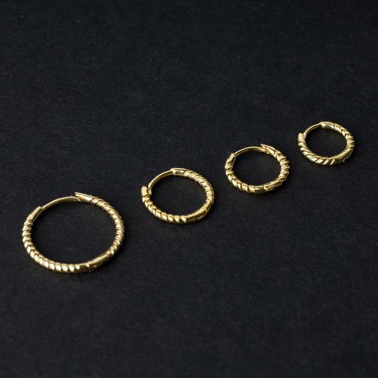 Gold rope-textured clicker rings in four different sizes, displayed on a dark background.