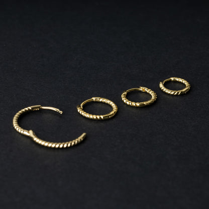 Gold rope-textured clicker rings in four different sizes, displayed on a dark background.
