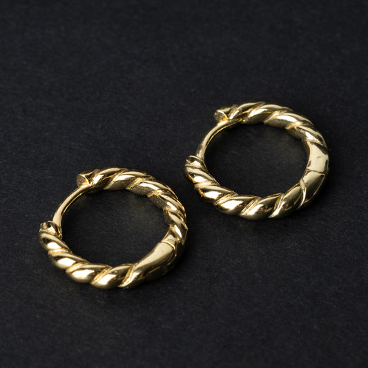 Pair of small gold braided hoop earrings, displayed on a dark background.