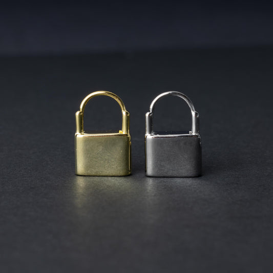 Two padlock-shaped earrings made from 925 sterling silver, one in a gold-tone and the other in silver-tone, displayed on a dark background.