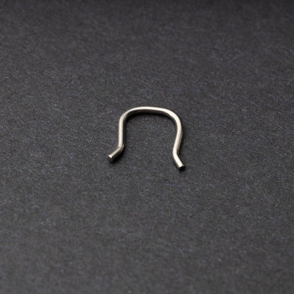U-shaped septum retainer in silver displayed on a dark background