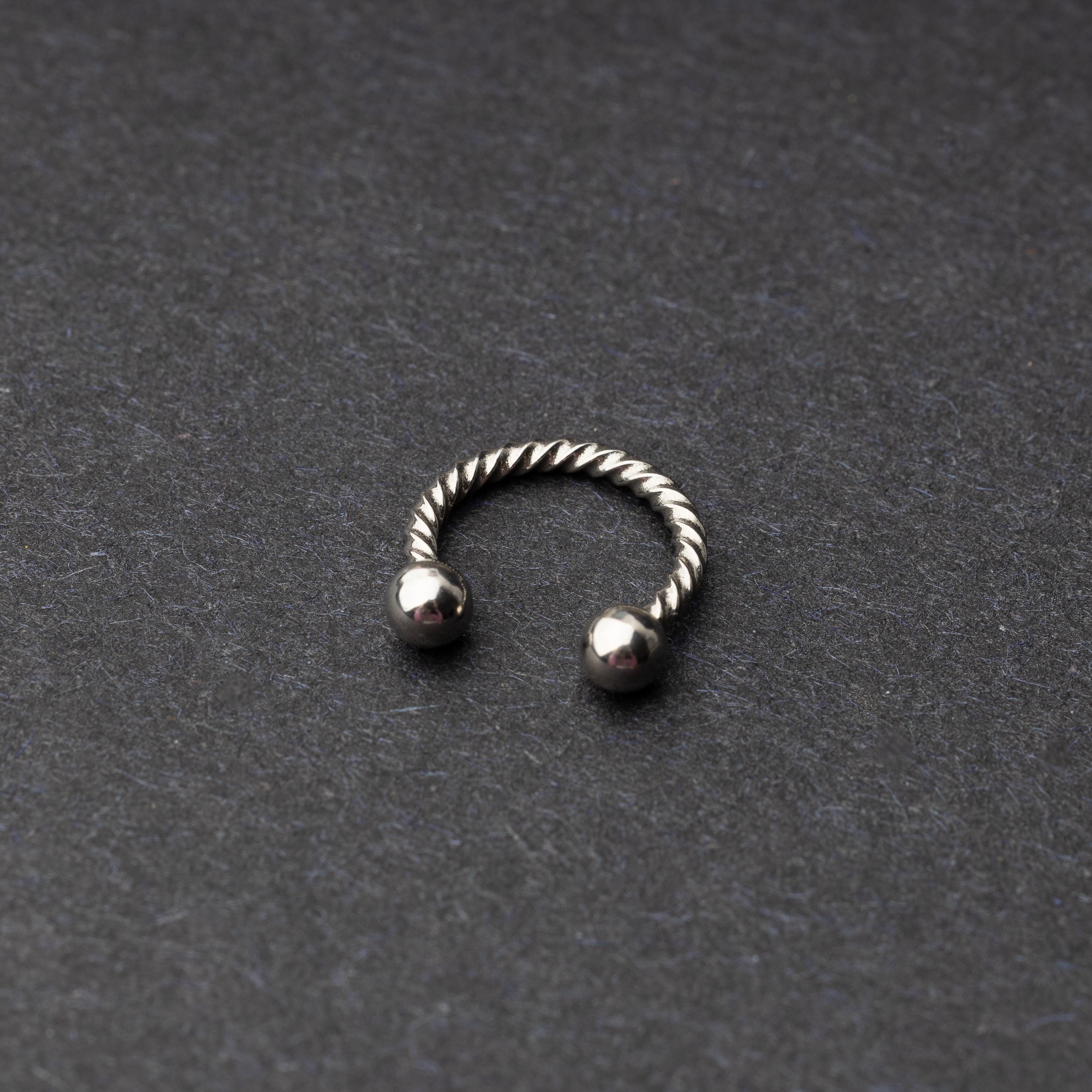 Twisted horseshoe barbells in silver finish displayed on a dark background, highlighting their bold and unique design.