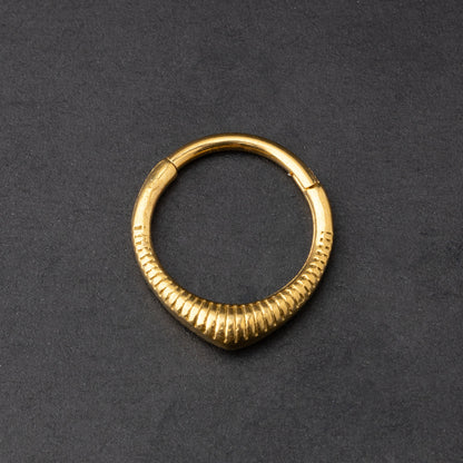 Gold  ribbed septum clicker jewelry displayed on a dark background, showcasing a sleek, modern design
